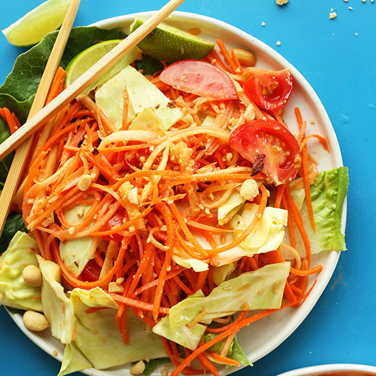 Chopsticks resting on a plate of our Thai Papaya Salad recipe